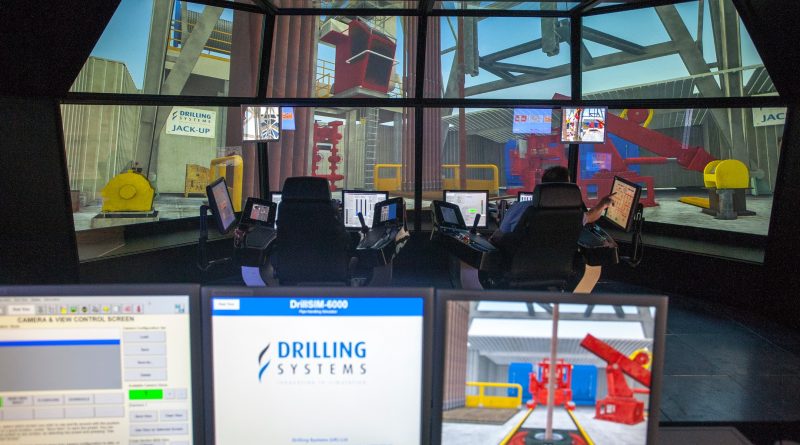 Two operators sit in a control room using advanced simulation software from Drilling Systems to manage virtual oil and gas drilling operations displayed on multiple screens.