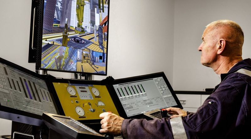 An operator closely monitors and controls machinery using multiple screens and controls in a high-tech industrial setting.